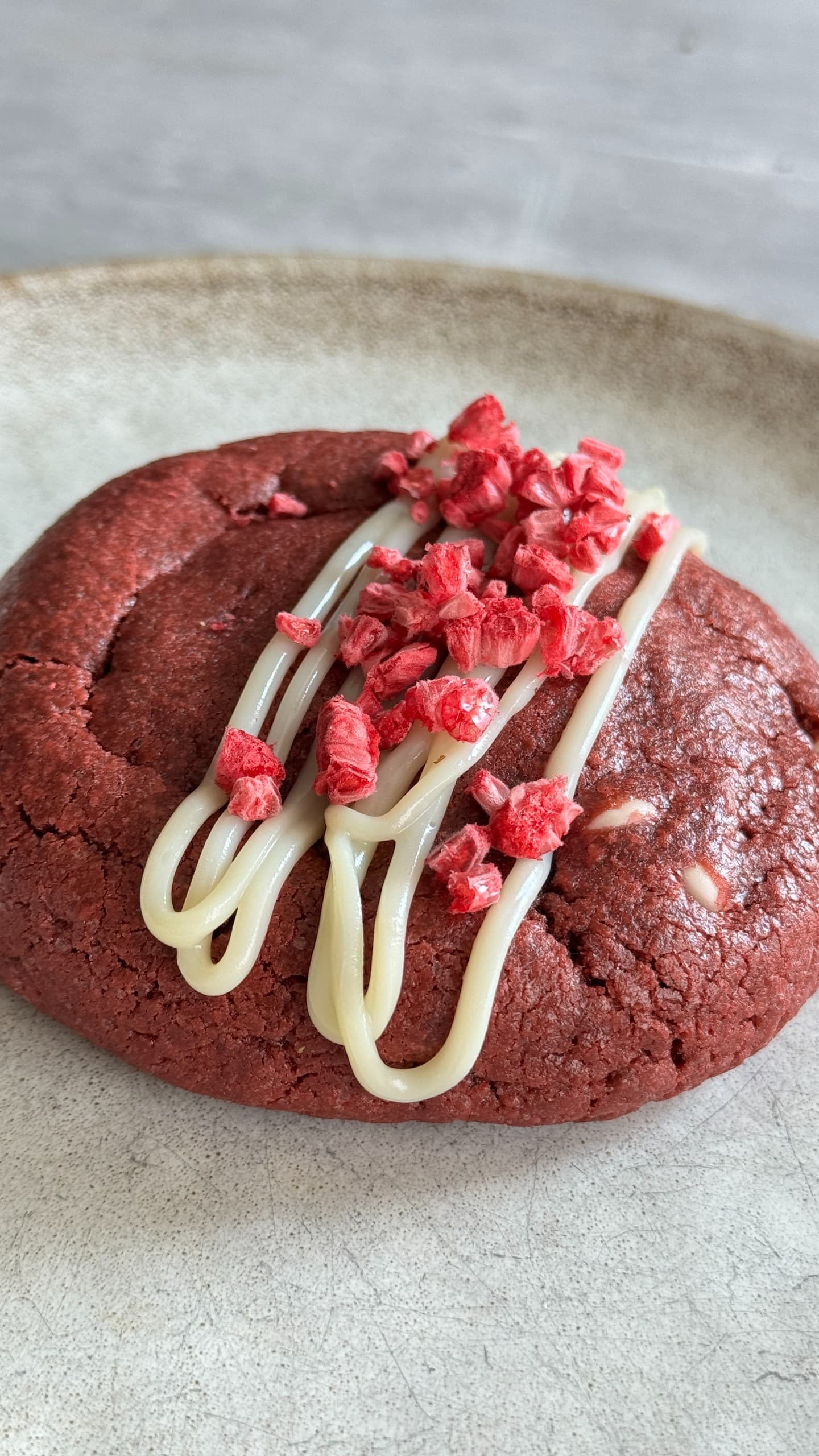 Red velvet cookie with raspberry cheesecake filling, sliced to show the creamy center.